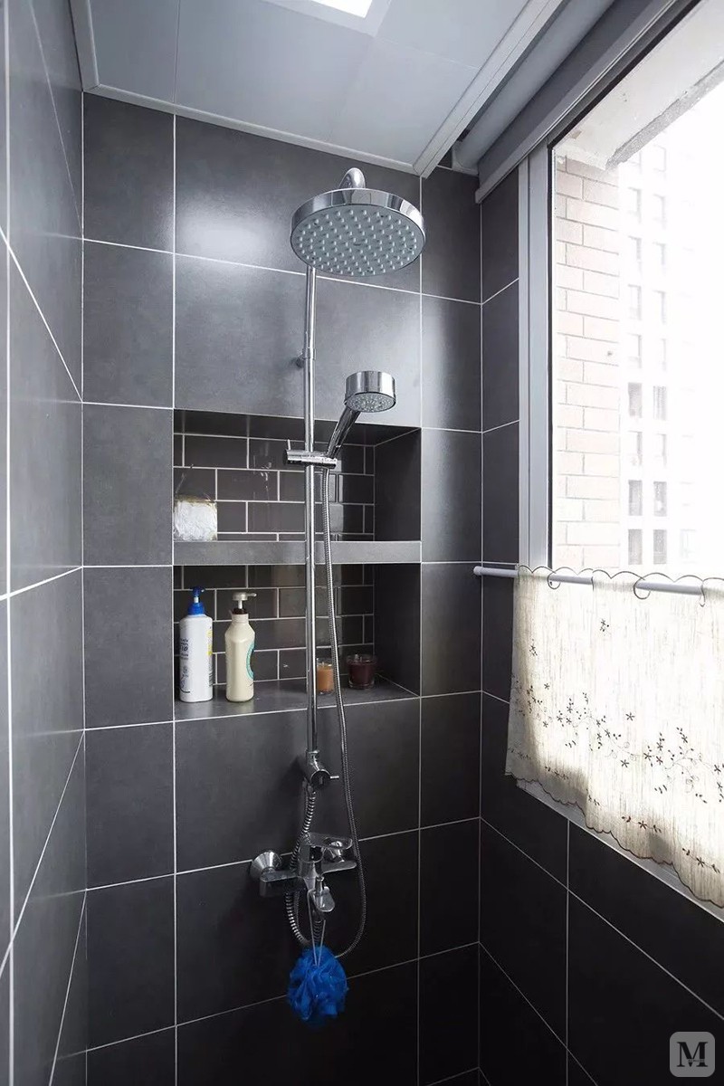 淋浴区以深灰色的空间,淋浴花洒前方的墙面还挖了2个壁龛,摆上淋浴