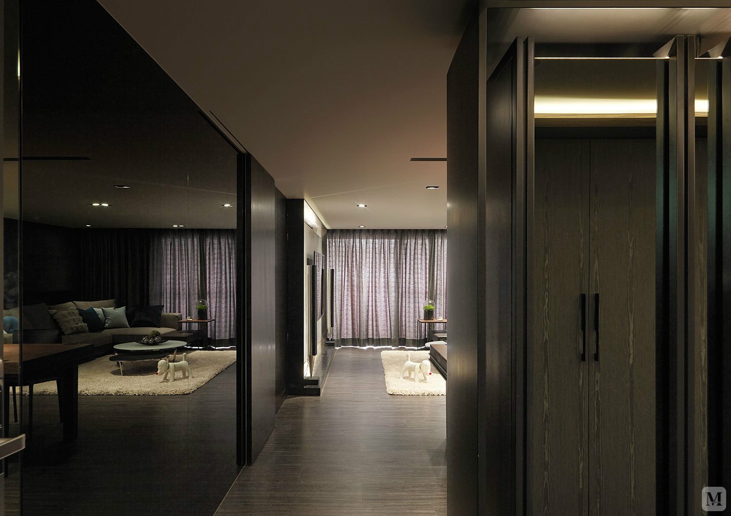 沙发区域整体冷静色调,深色沙发搭配了亮橙色系的沙发背景墙与装饰画.