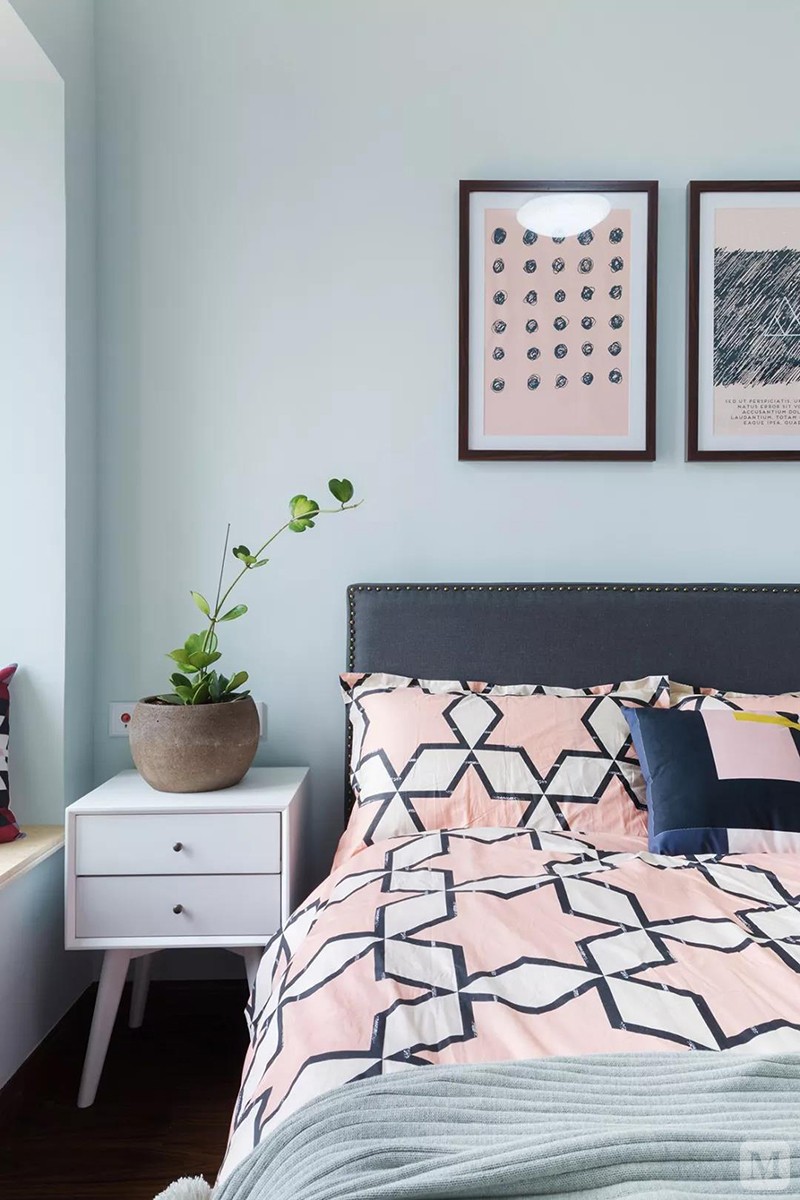天蓝色床头墙,搭配黑色床头靠背,铺上粉色图案的床单,对称地布置了