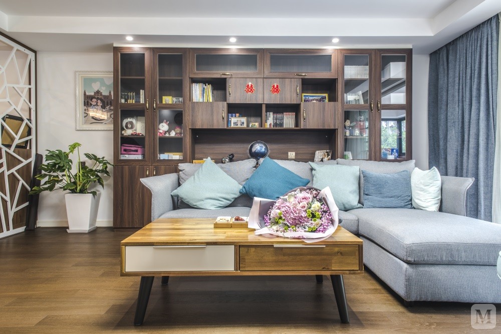 1、客厅区域整体的硬装设计主要是以白色和雾蓝为主，家具大多采用原木和胡桃木，蓝色布艺沙发让整个空间生机勃勃，木制的家具+布艺的沙发空间的品质就这样体现的恰到好处。