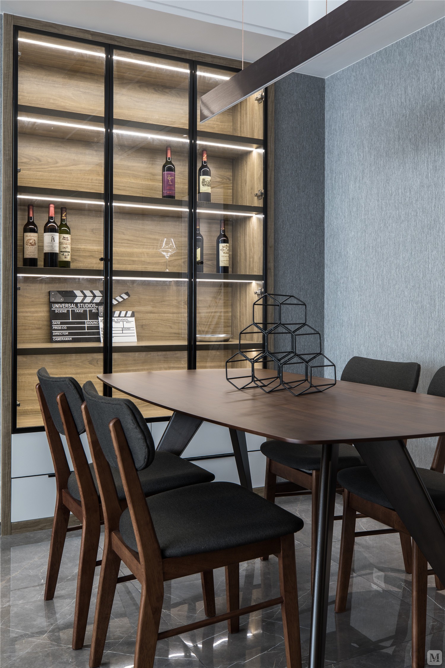 餐厅的餐边柜的层板灯增加了线条感,窄框灰玻更显通透,餐桌上方的吊灯