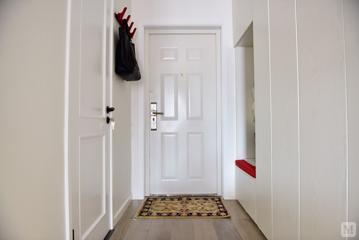 门厅玄关，做了换鞋的区域方便使用，没有加把手的柜子显得更加简洁。 红色的坐垫是为了和卧室飘窗的红色坐垫有个呼应。